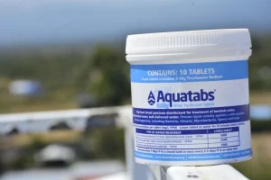 Aquatabs 8.68g water purification tablets – tub of 10 placed on a fence rail outdoors